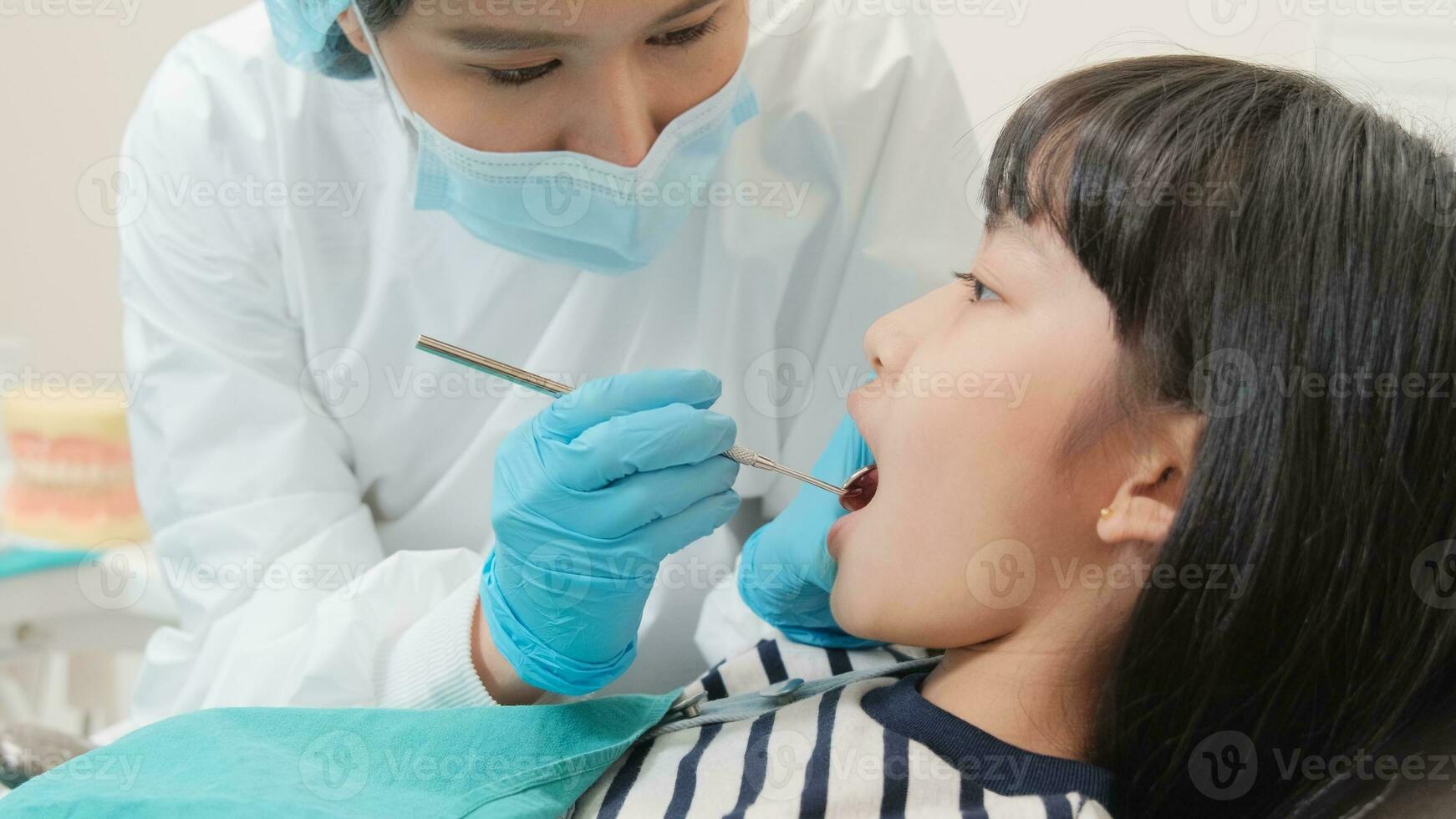 asiatisk kvinna tandläkare undersöka ung flicka patient tänder och tandvärk stomatologi i dental klinik, välbefinnande hygien checkar, och professionell ortodontisk sjukvård arbete i läkares kontor sjukhus. foto