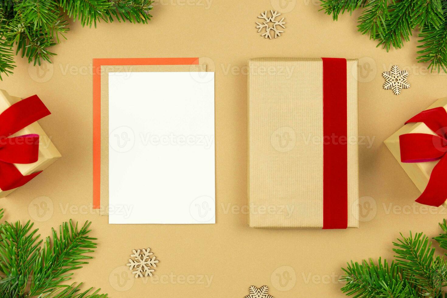 jul hälsning kort attrapp och insvept gåva låda mall med röd band och jul träd grenar dekoration på papper bakgrund. festlig platt lägga styled sammansättning. topp se. foto