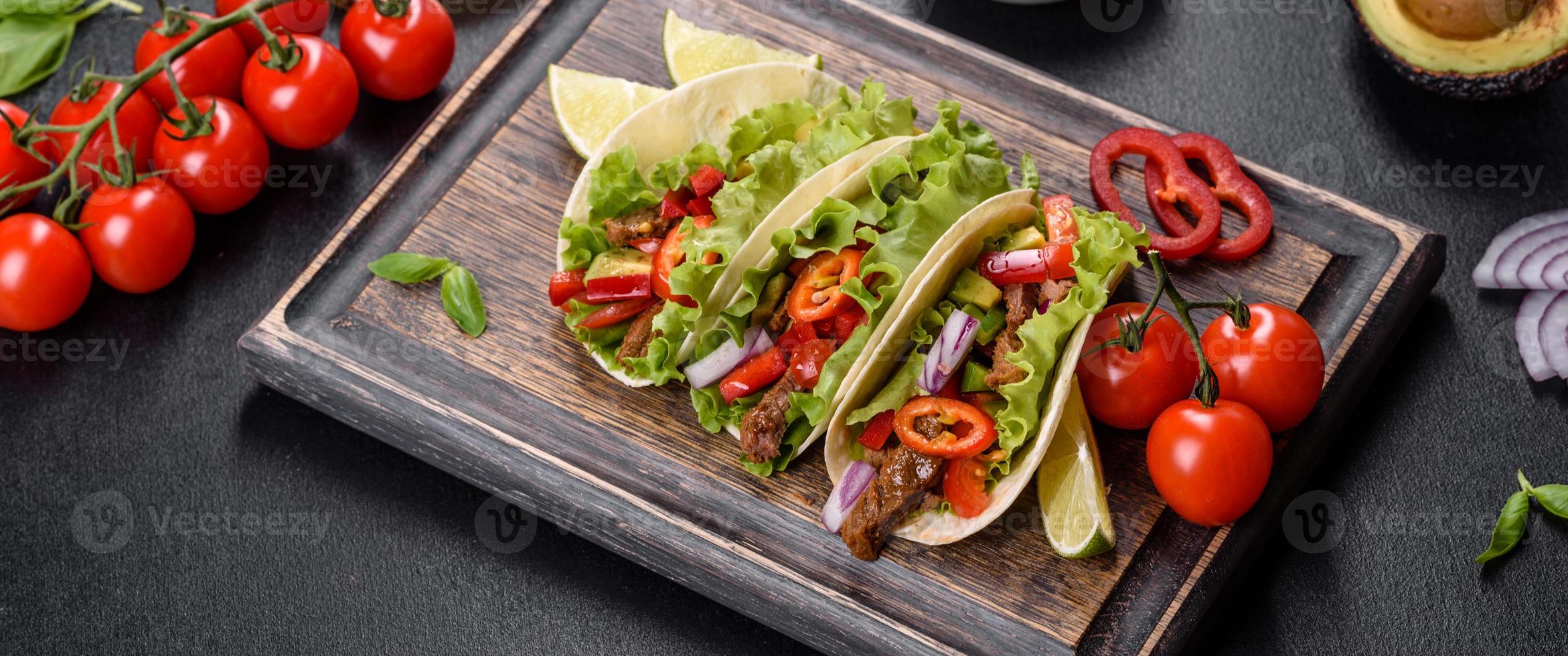 mexikansk tacos med nötkött, tomater, avokado, lök och salsasås foto
