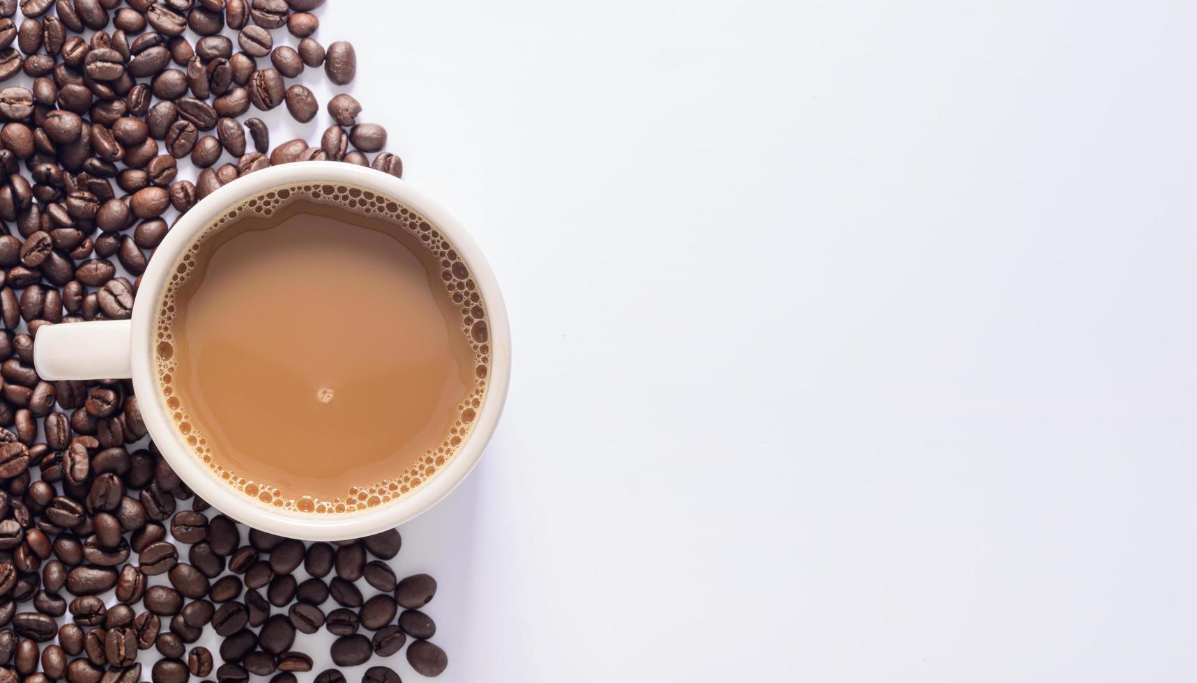 kaffemugg, kaffebönor, vit bakgrundsscen foto