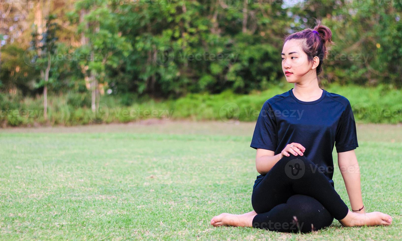 vacker asiatisk kvinna - yoga i parken foto