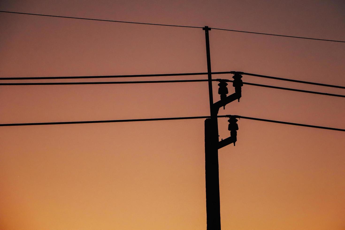 silhuett elektrisk stolpe och solnedgång. foto