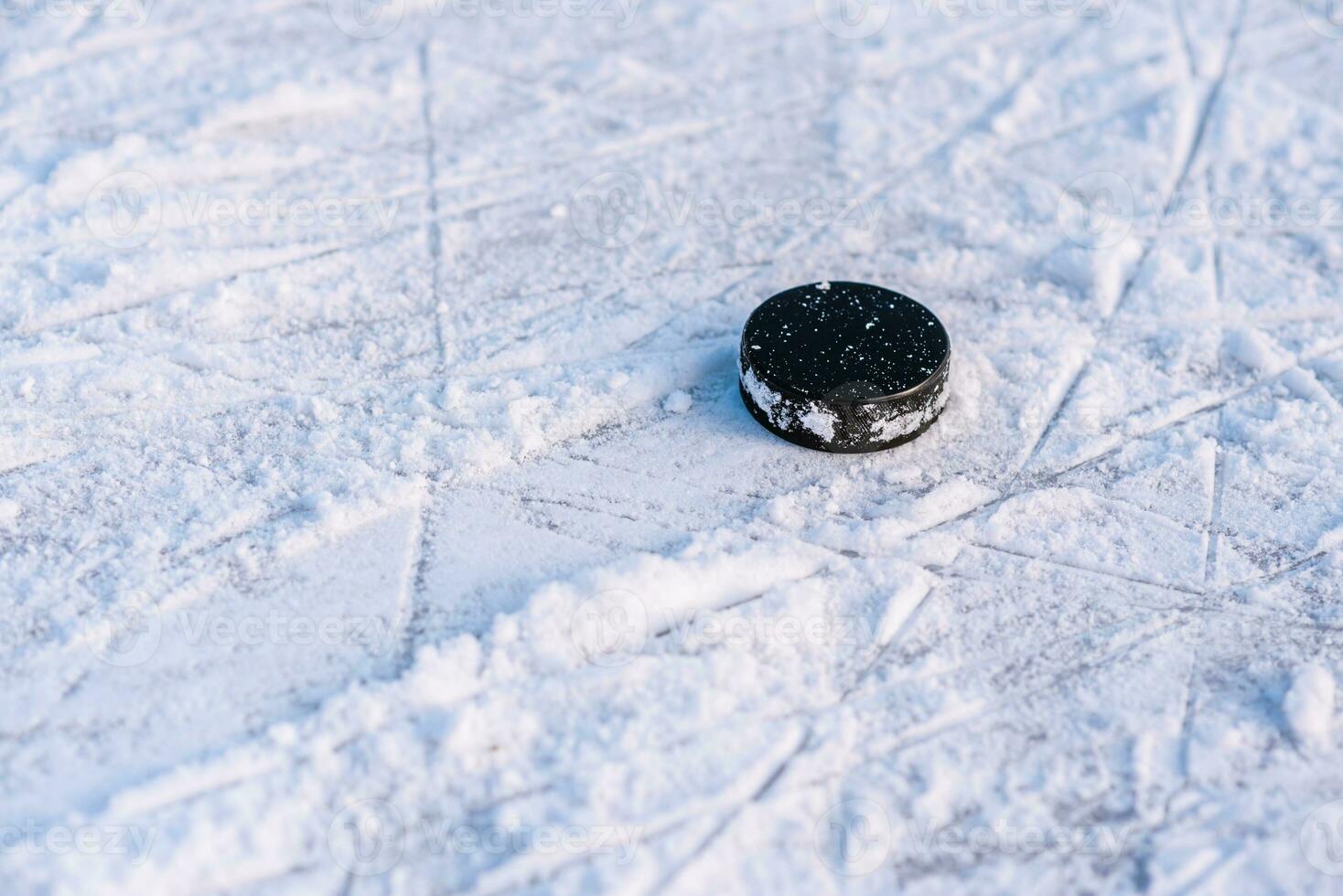 svart hockey puck lögner på is på stadion foto