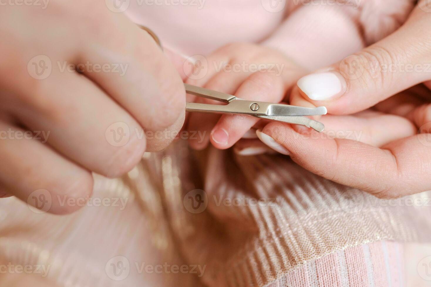 mor nedskärningar naglar till liten bebis foto
