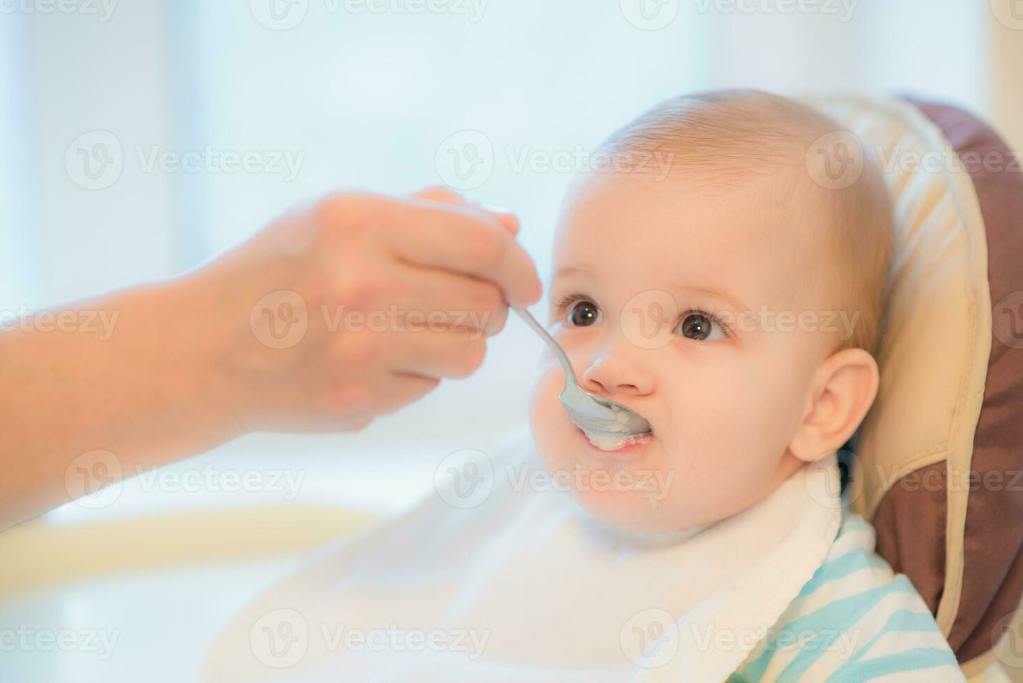 mormor ger bebis mat från en sked foto