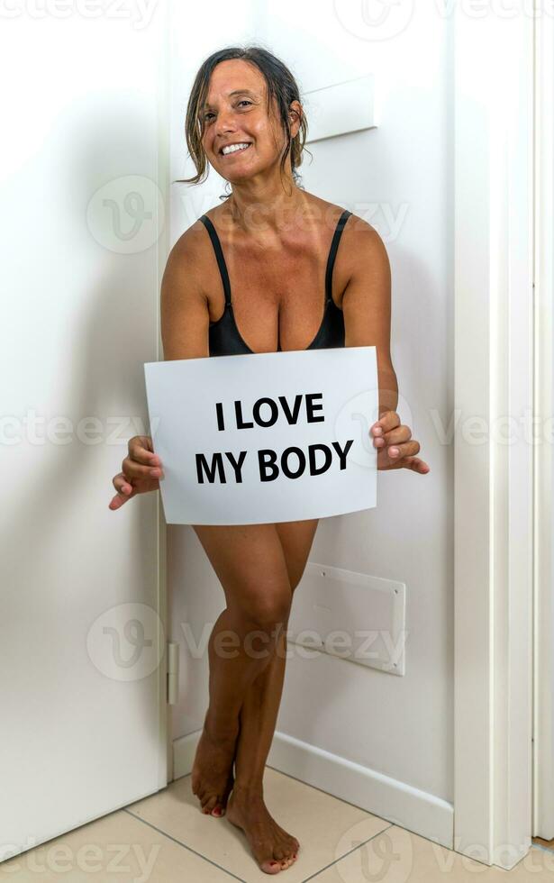 bild av en skön mitten åldrig kvinna Framställ i henne lägenhet - begrepp handla om kropp positivitet själv aktning och kropp godkännande foto