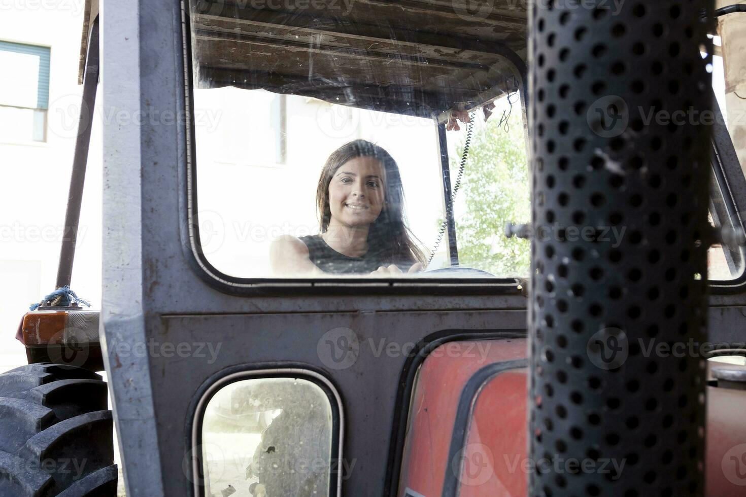 skön ung kvinna Sammanträde på en traktor foto