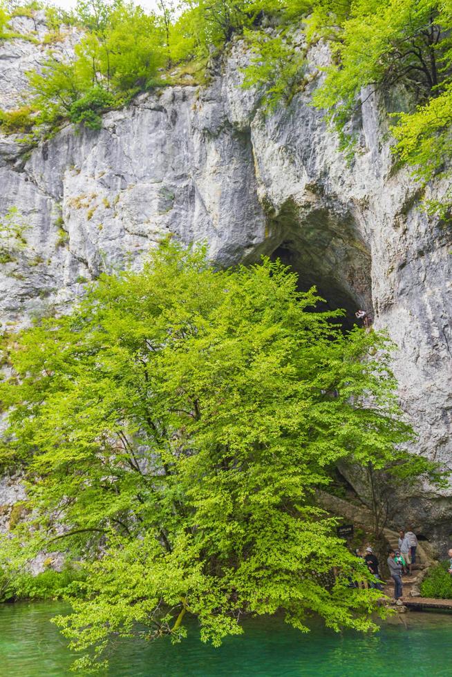 turister vid en grotta i nationalparken Plitvice Lakes, Kroatien foto