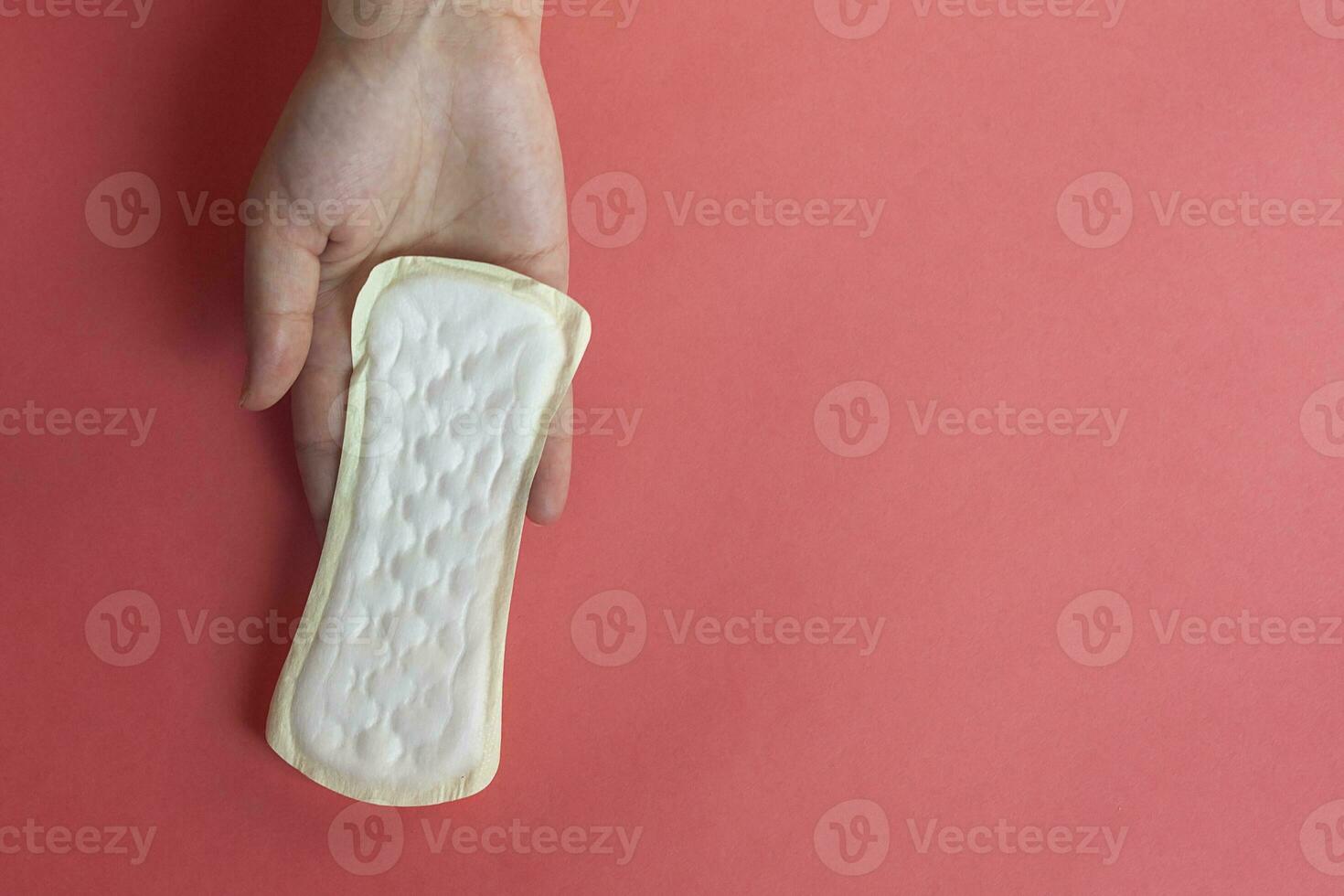 kvinnas händer innehav en feminin hygien vaddera. händer av kvinna håll menstruations- dynor eller sanitär bindor för kvinnor foto