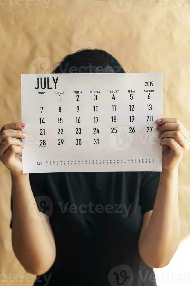 en kvinna innehav enkel juli 2019 kalender foto