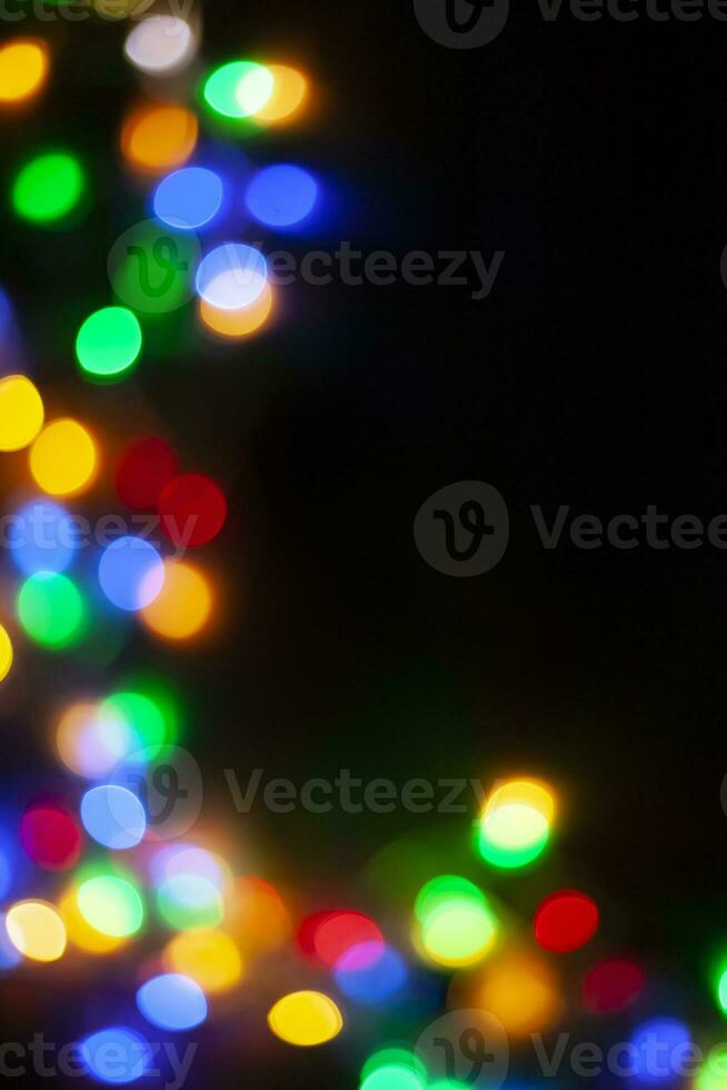 xmas bakgrund bild. dekorativ jul lampor bokeh. defocused bild av jul krans lampor på mörk foto
