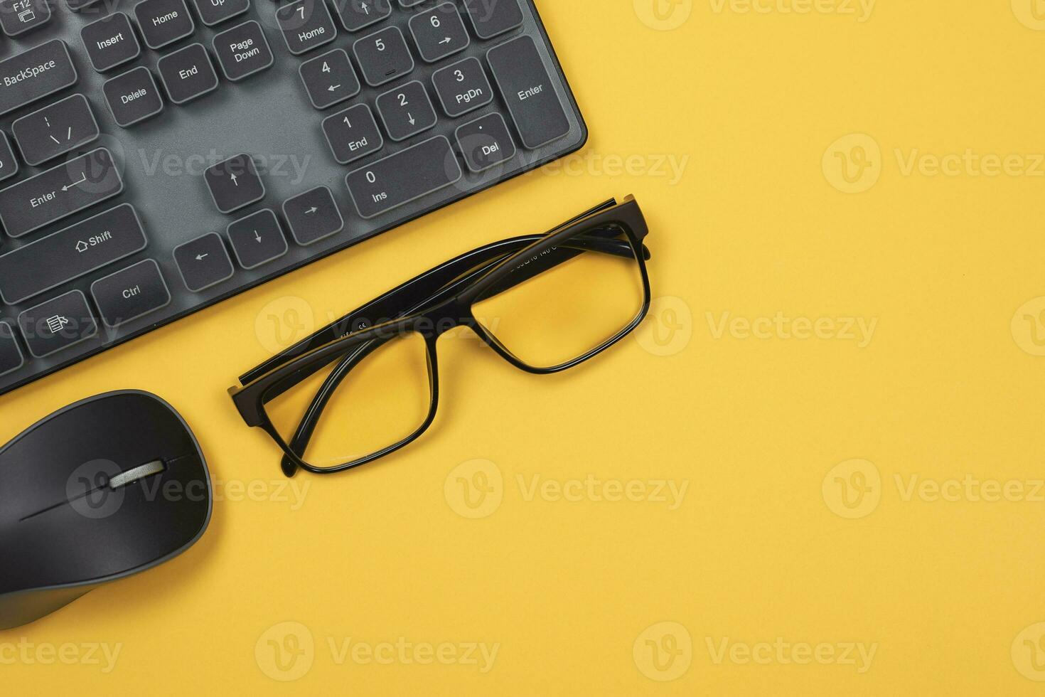pc mus, tangentbord och glasögon på gul foto