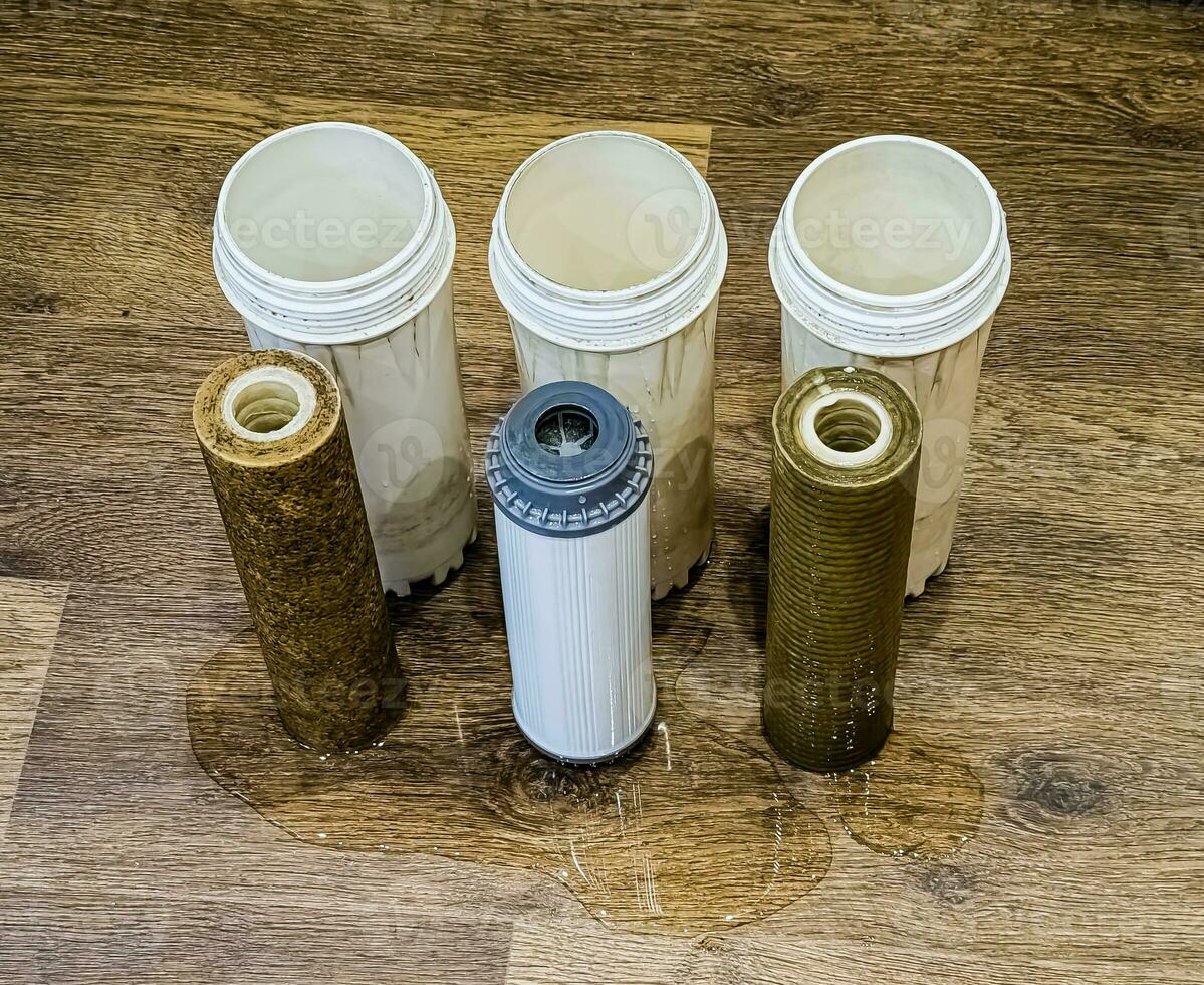 tre Begagnade vatten filter med spår av smuts, lera och föroreningar. byter ut flersteg vatten filtrera patroner. foto