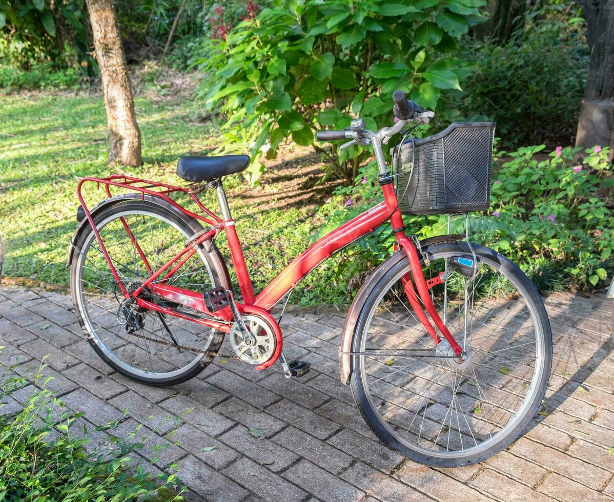 antik söt röd cykel parkera på väg foto