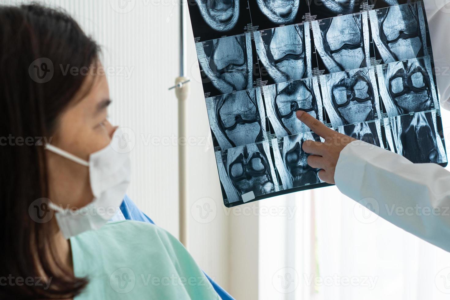 ortopedist visar magnetisk resonansavbildning av knä till patient foto