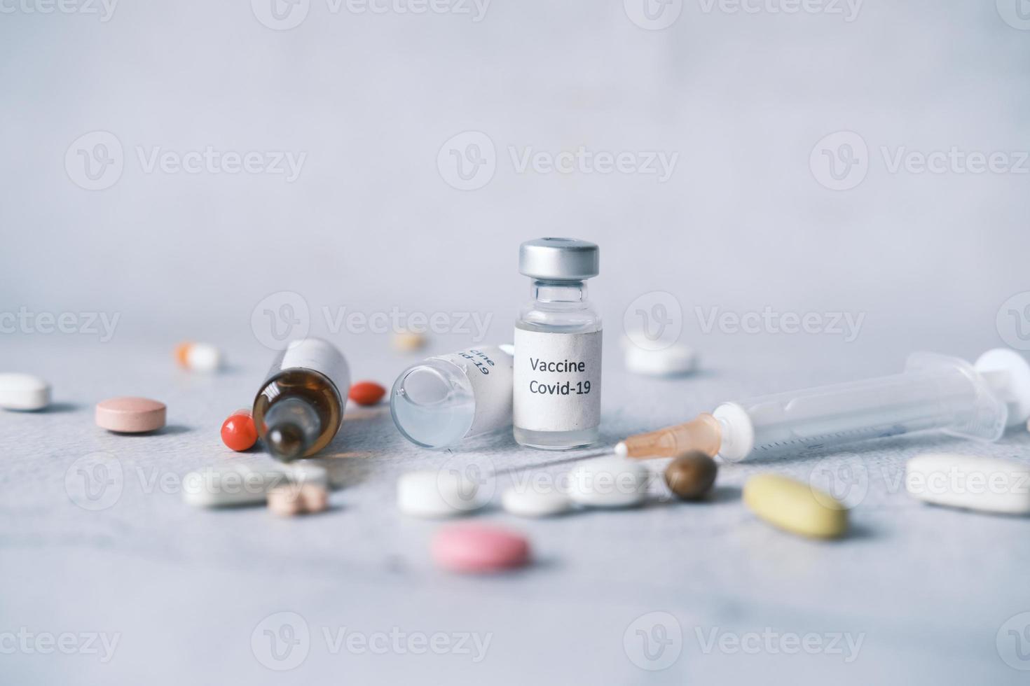 närbild av coronavirusvaccin, medicinska piller och spruta på vitt foto