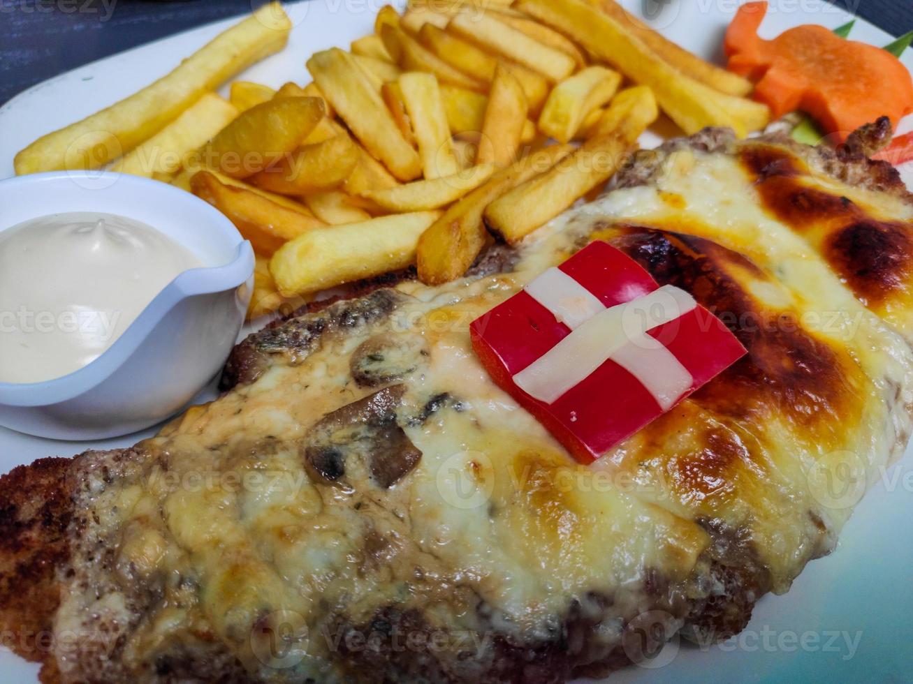 schnitzel med pommes frites och sås med färska grönsaker foto