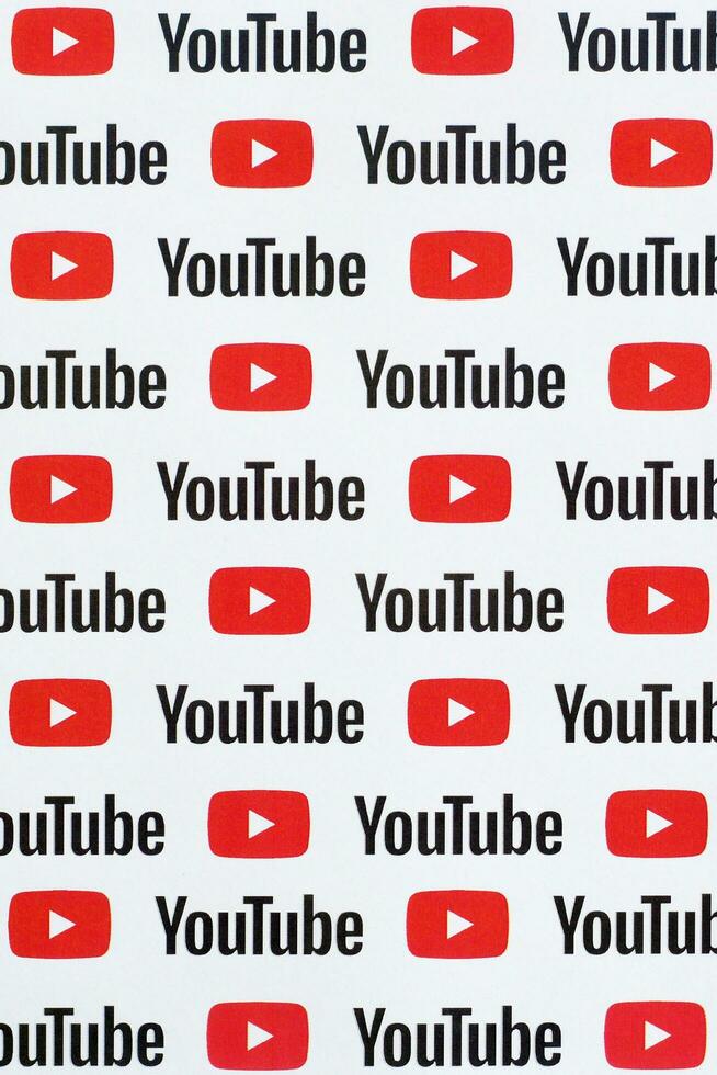 Youtube mönster tryckt på papper med små Youtube logotyper och inskriptioner. Youtube är Google dotterföretag och amerikan mest populär videodelning plattform foto