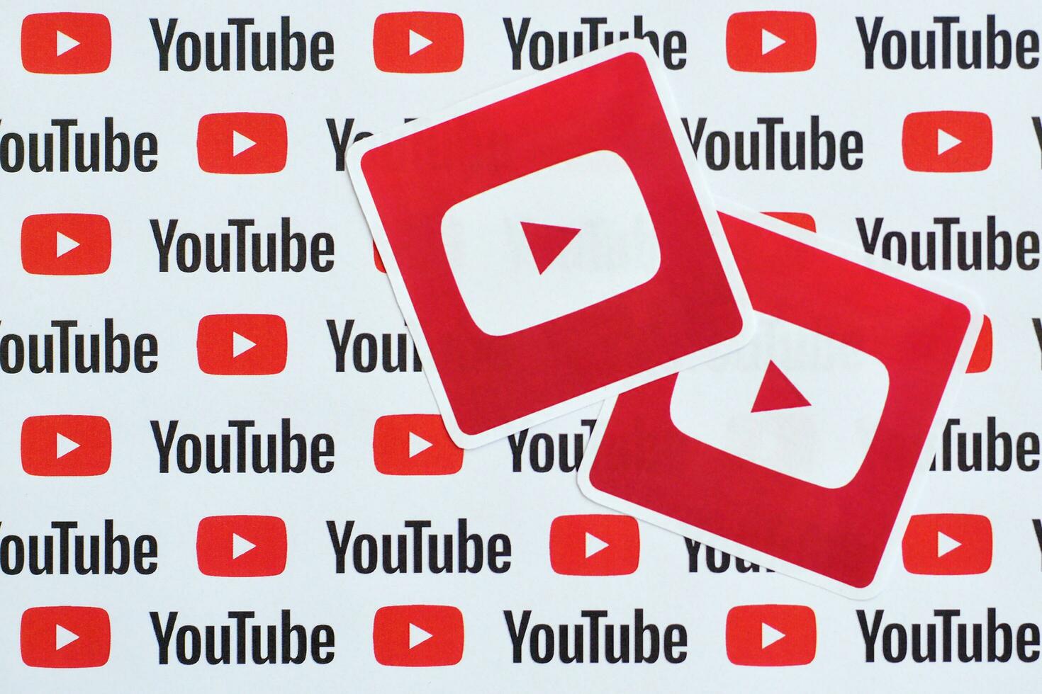 Youtube logotyp klistermärke på mönster tryckt på papper med små Youtube logotyper och inskriptioner. Youtube är Google dotterföretag och amerikan mest populär videodelning plattform foto