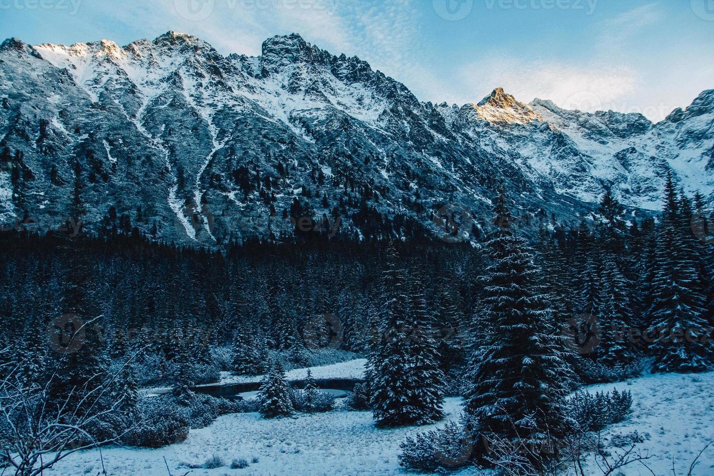 landskap med snötäckta toppar i de steniga bergen i soligt väder foto