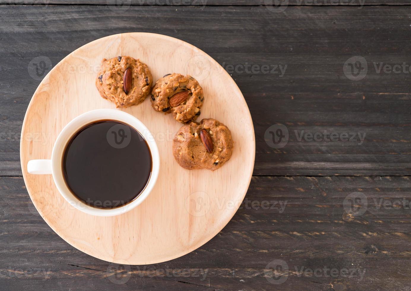 svart kaffe med kakor på trä foto