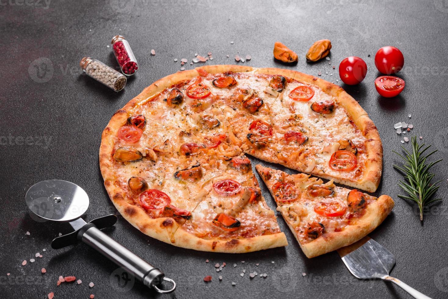 välsmakande skivad pizza med skaldjur och tomat på en betongbakgrund foto