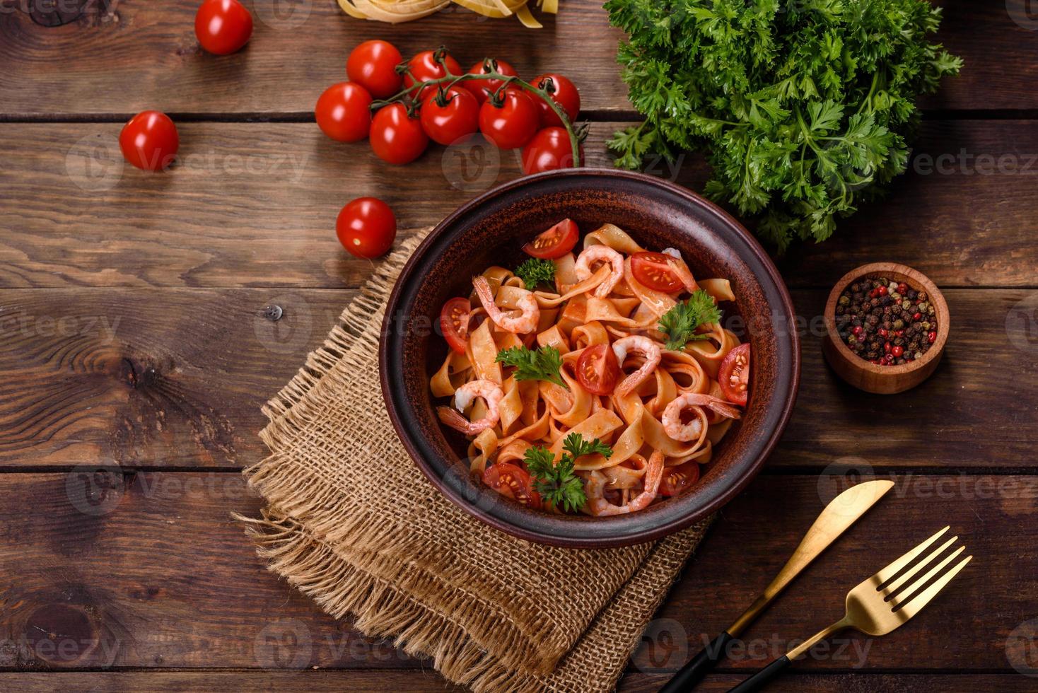 fettuccinapasta med räkor, körsbärstomater, sås, kryddor och örter foto