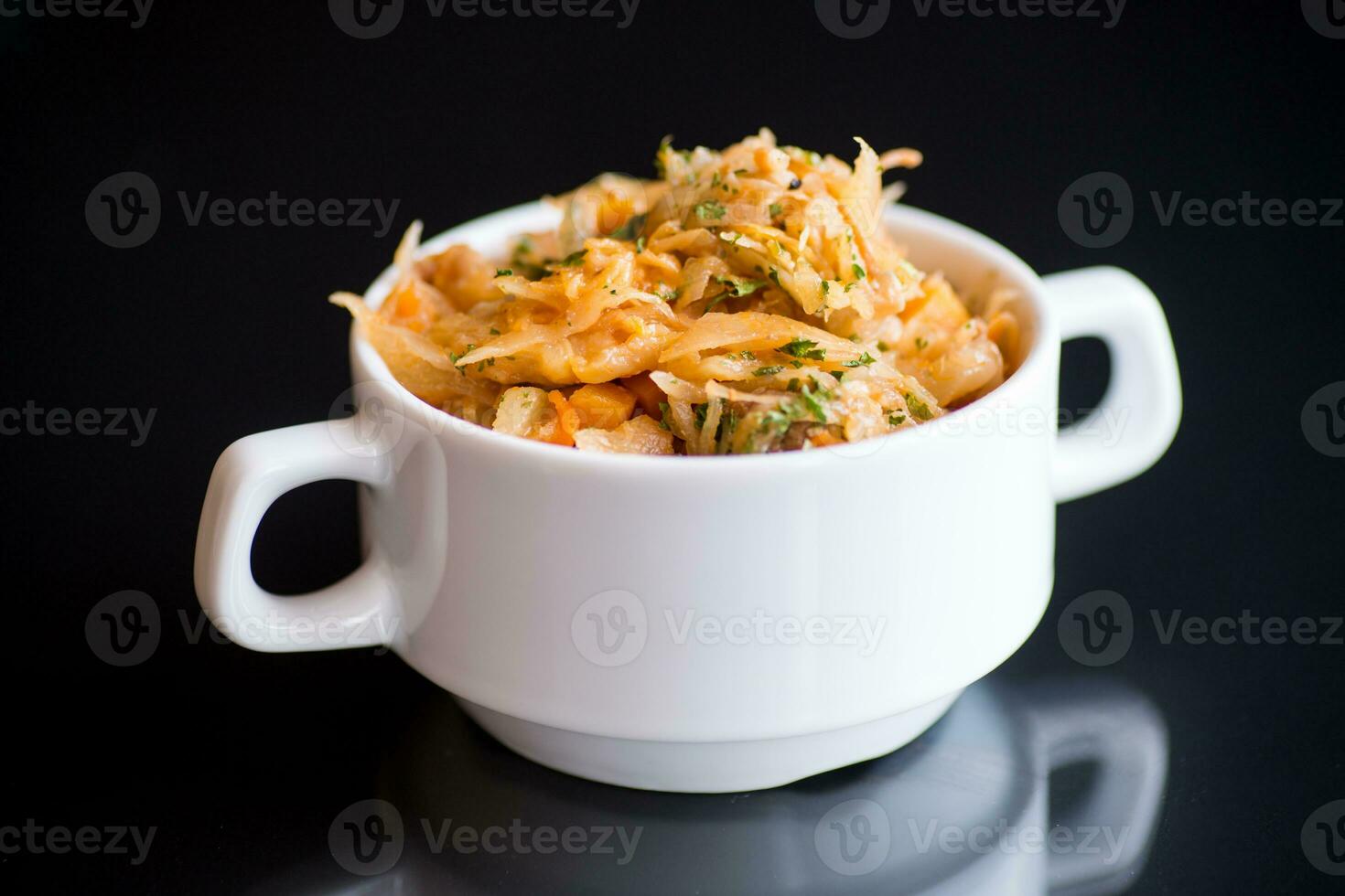 stuvad kål med morötter och kryddor i en skål foto