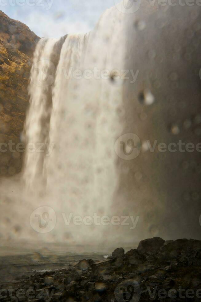 selektiv fokus av stor vattenfall i Island, vatten ström löpning ner från scandinavian isig klippor. spektakulär arktisk skgafoss kaskad faller av kullar kant formning isländsk landskap. foto