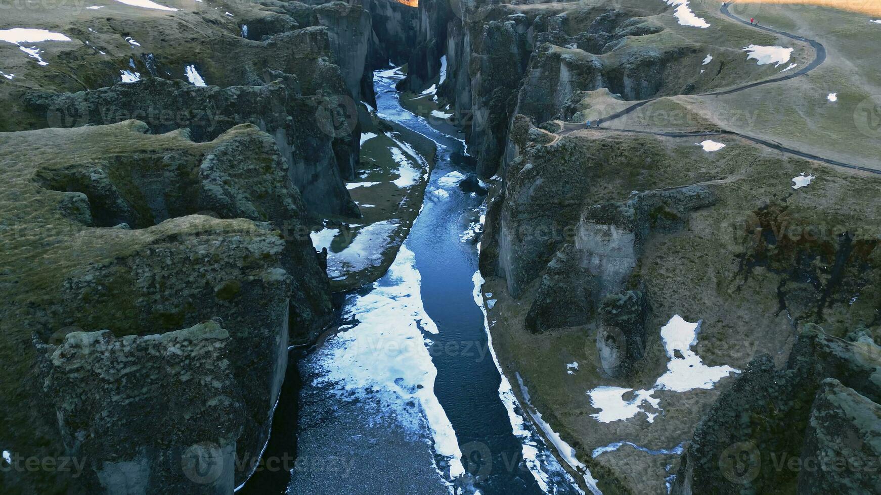 spektakulär fjadrargljufur kanjon antenn se med vatten ström och isländsk landskap, snöig bergen och massiv rocks. majestätisk nordic landskap med flod strömmande mellan kullar. långsam rörelse. foto