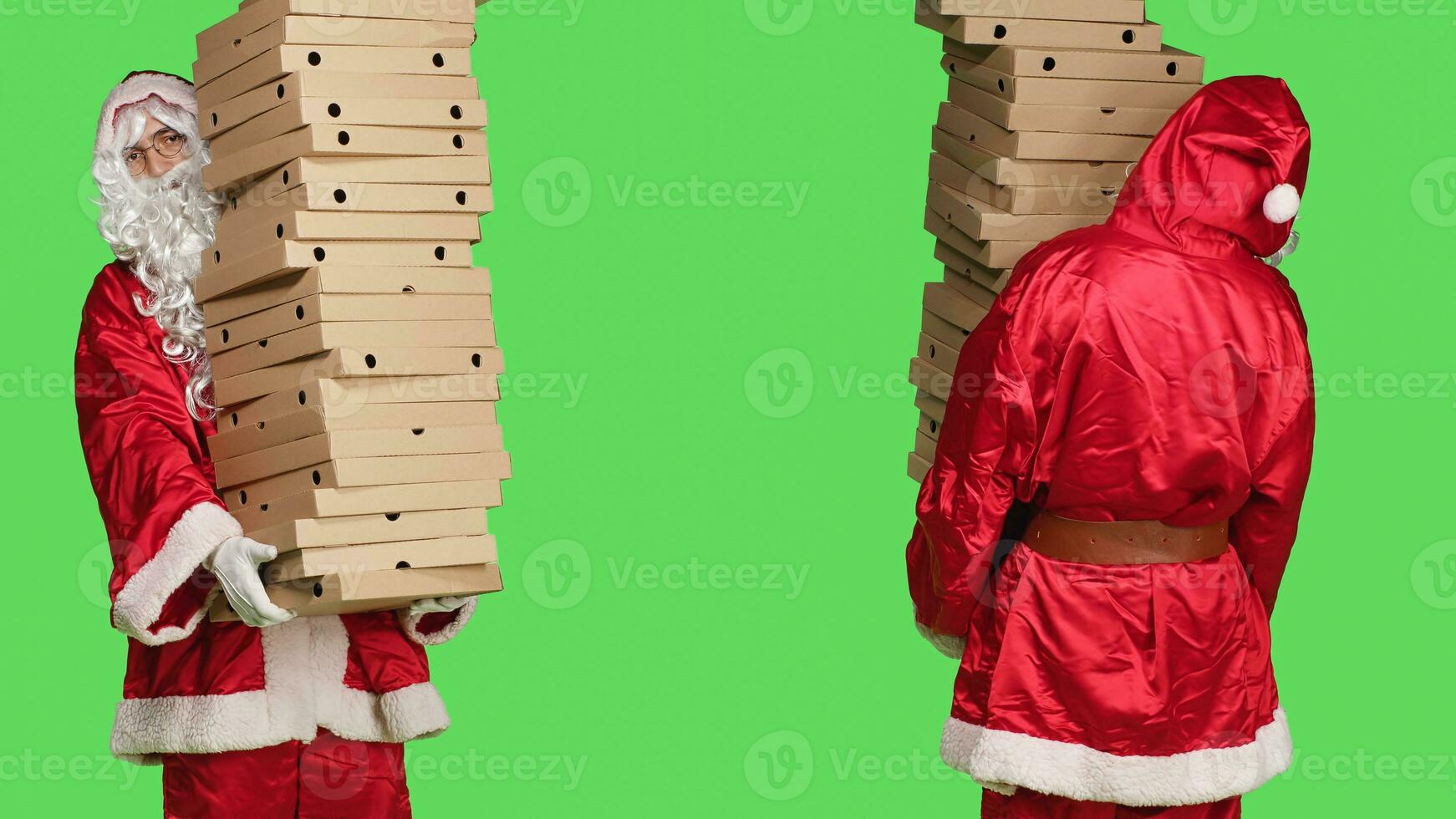 xmas karaktär med stack av pizza lådor, bärande stor lugg av leverans mat, person bär festlig karaktär santa claus kostym med vit skägg. man stående över grönskärm. foto