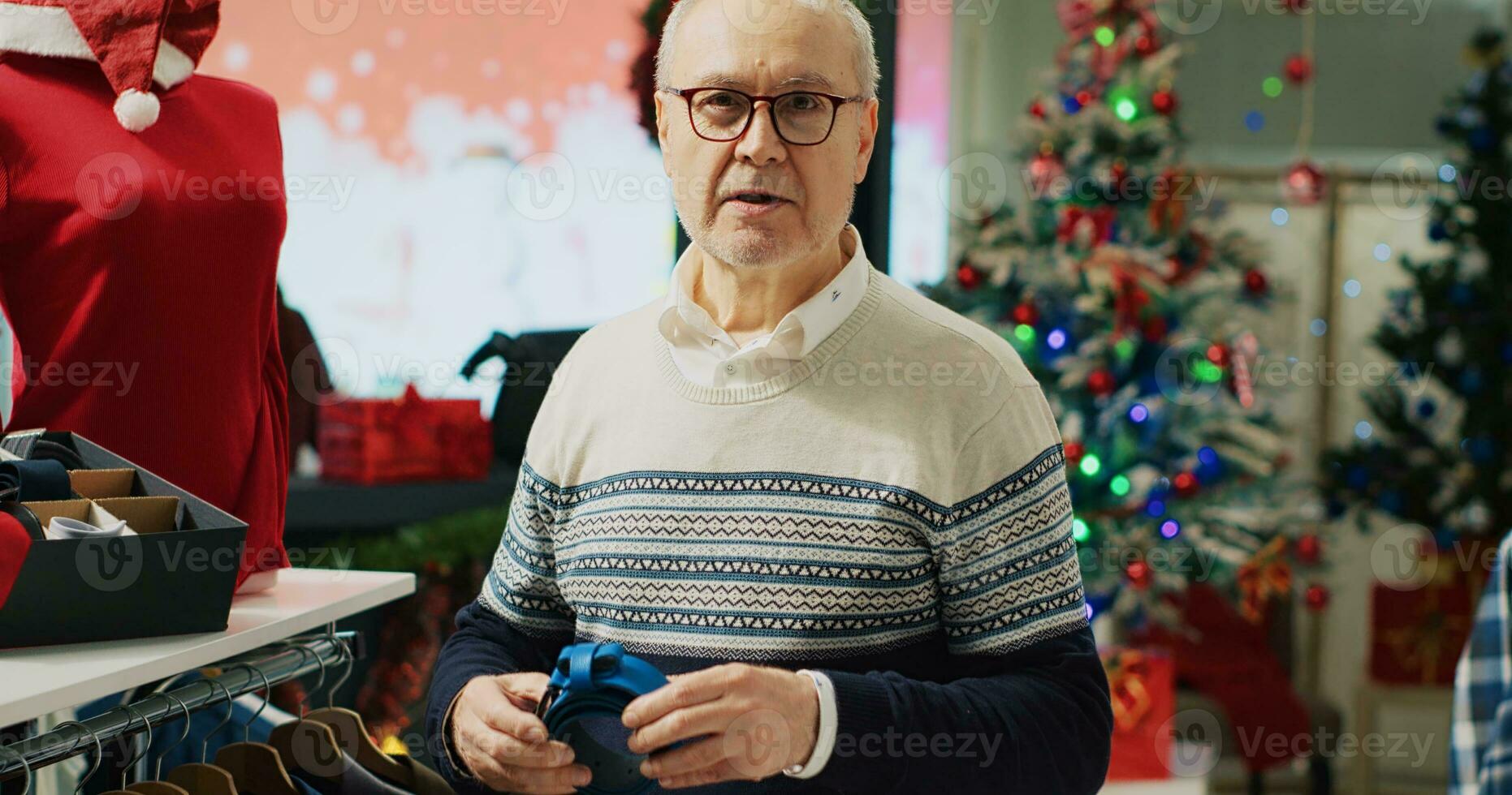 äldre klient ser på bälten, beundrande skön hantverk medan handla i jul dekorerad Lagra. gammal kund i köpcenter mode boutique sökande för xmas gåvor till erbjudande familj foto