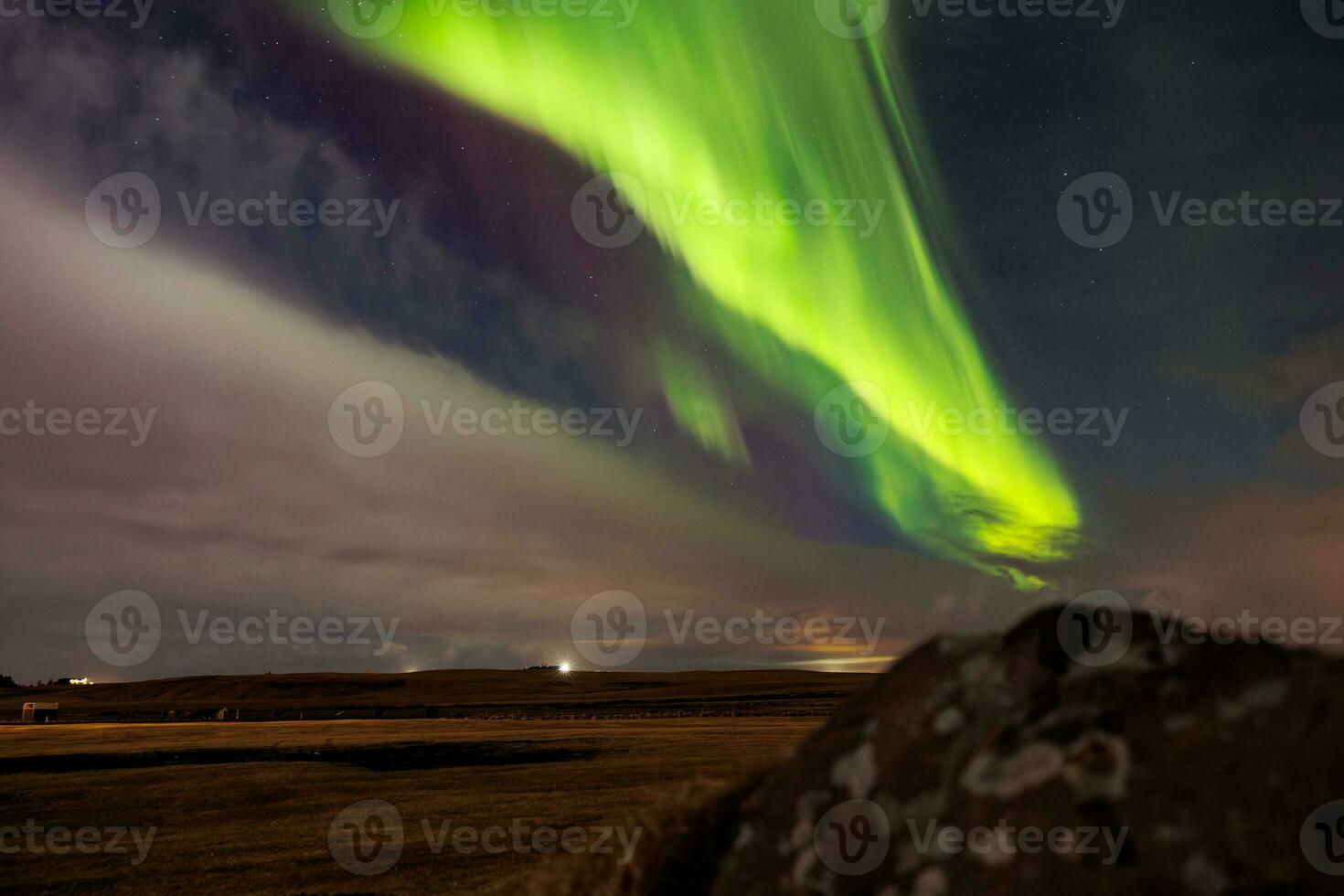 på solnedgång i Island, aurora borealis ljusnar upp natt himmel i utestående nyanser av grön och violett, formning magisk isländsk landskap. stjärnor gnistra runt om nordlig lampor. foto