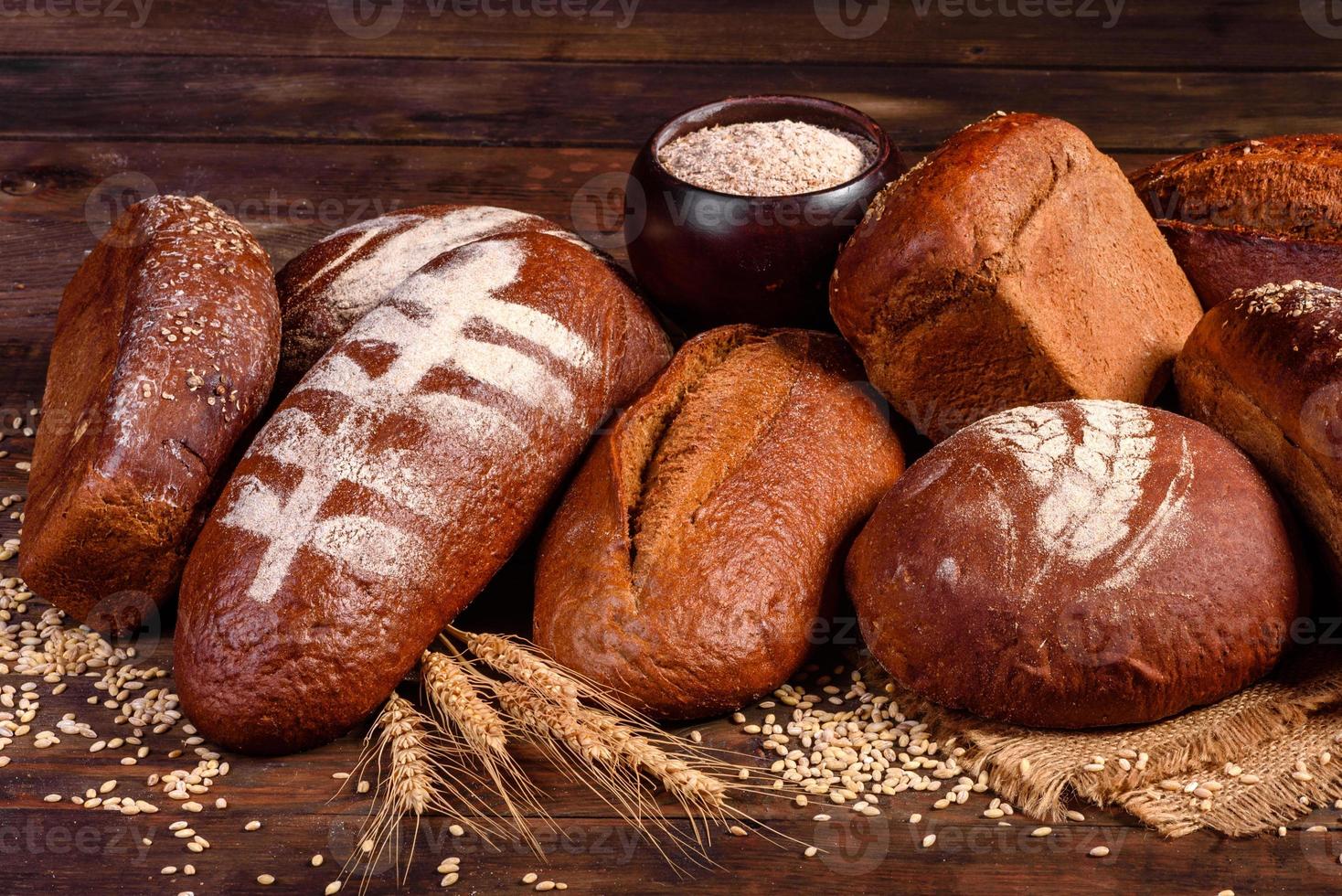 nybakat brunt bröd på en brun träbakgrund foto