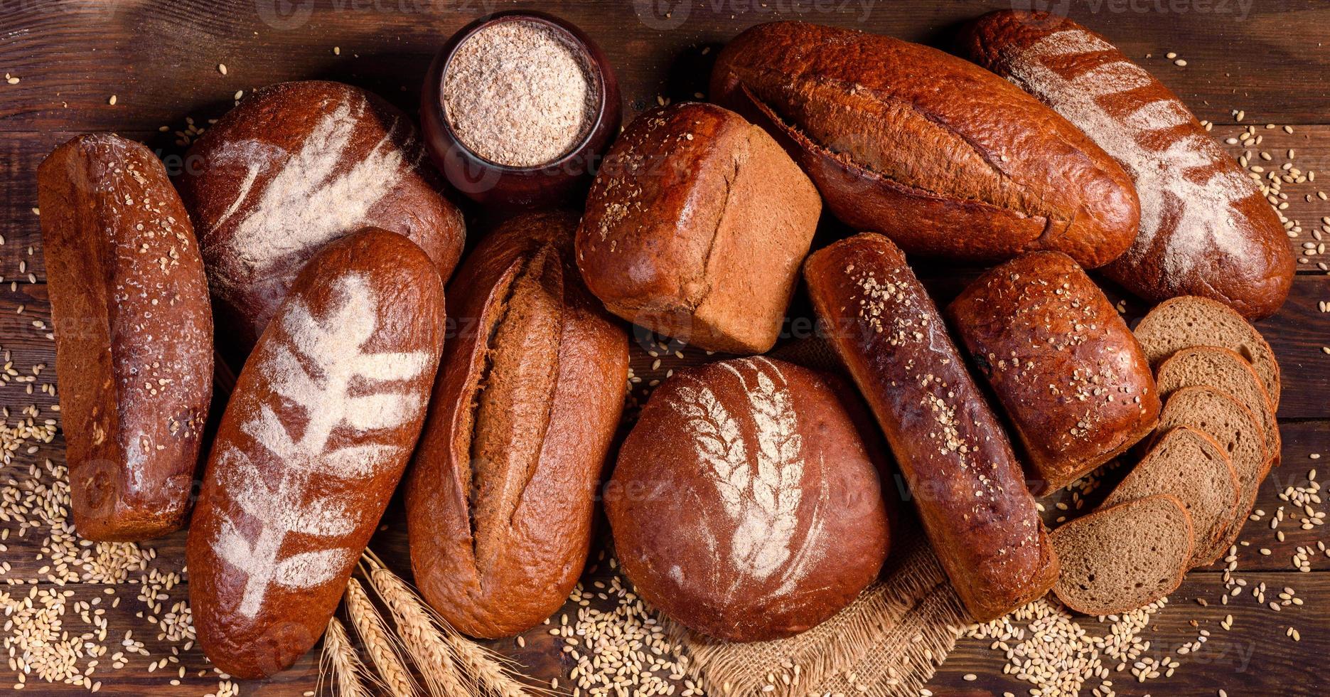 nybakat brunt bröd på en brun träbakgrund foto