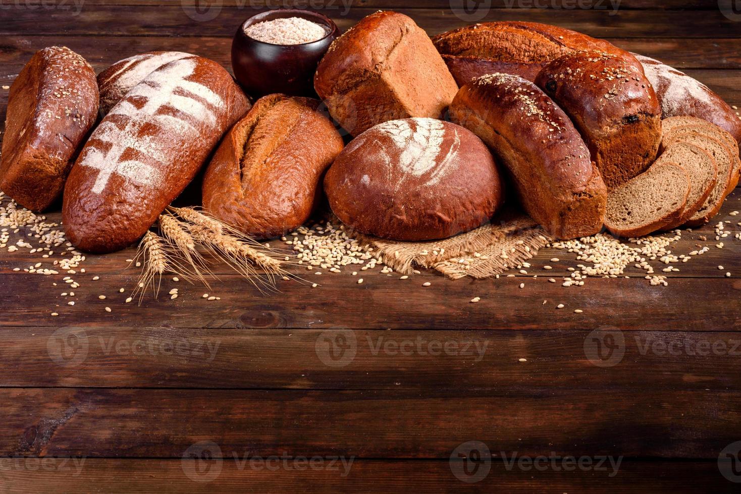 nybakat brunt bröd på en brun träbakgrund foto