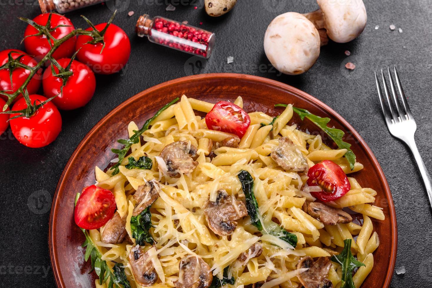 pasta med svamp, ost, spenat, rukkola och körsbärstomater foto