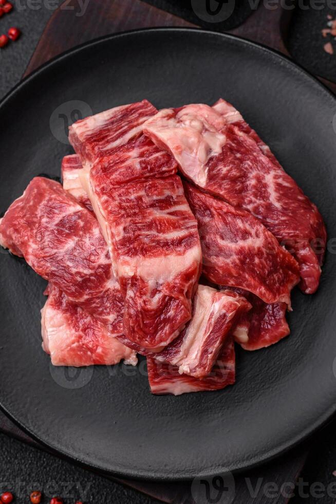färsk saftig rå nötkött skivor med salt och kryddor foto
