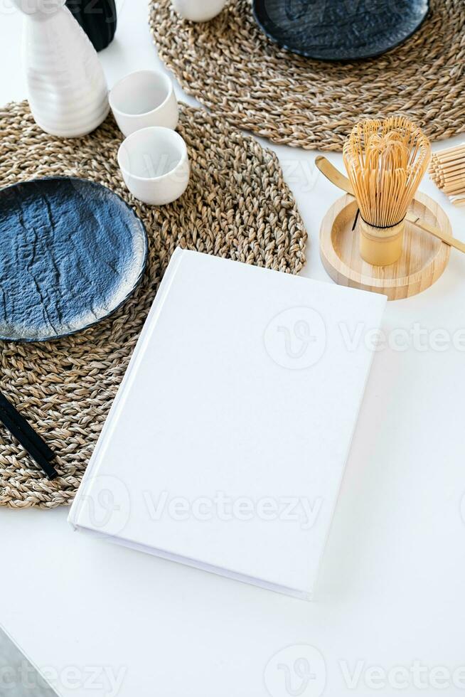 bok attrapp design. tom vit bok på dining tabell i asiatisk stil med porslin foto