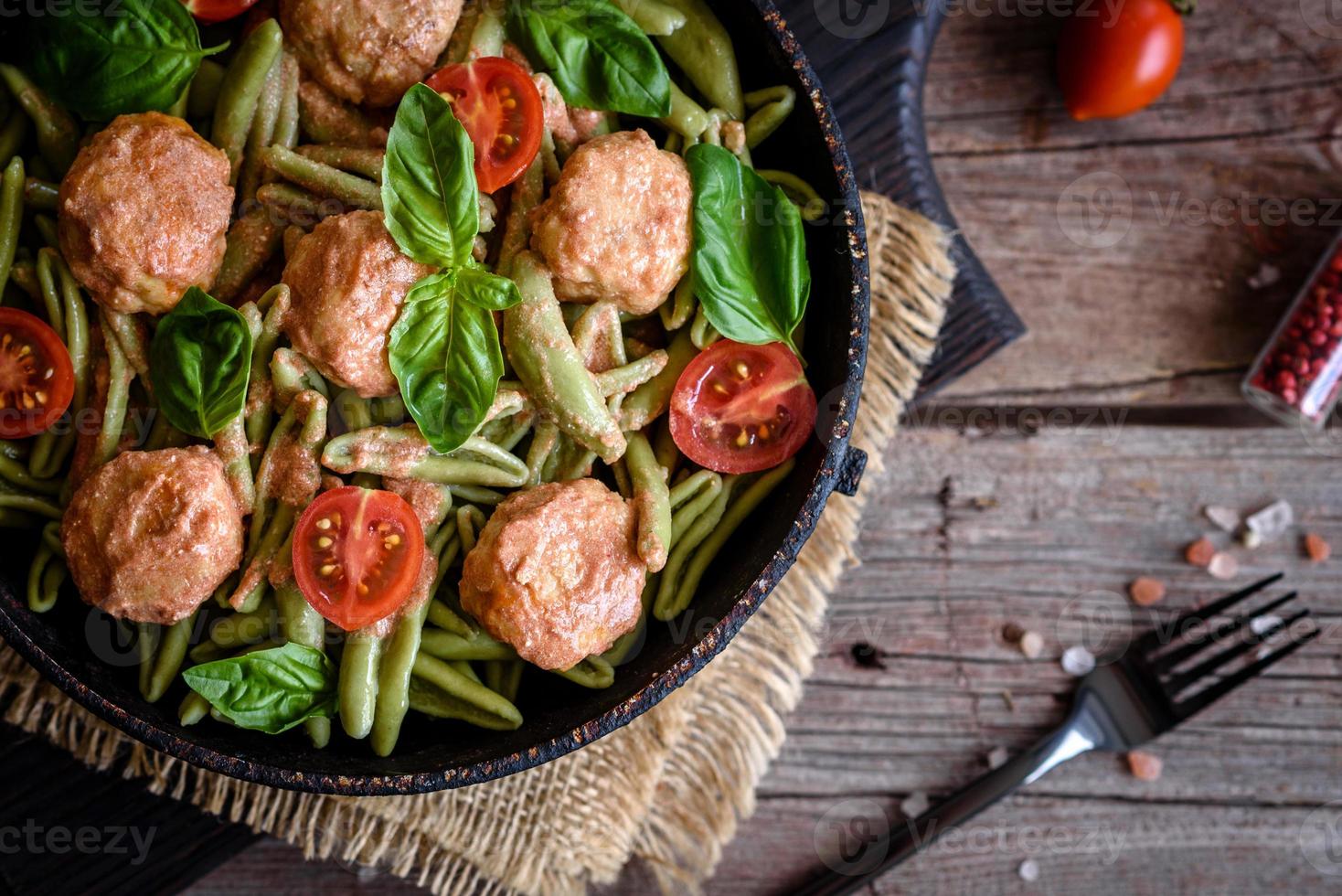 utsökt färsk pasta med köttbullar, sås, körsbärstomater och basilika foto