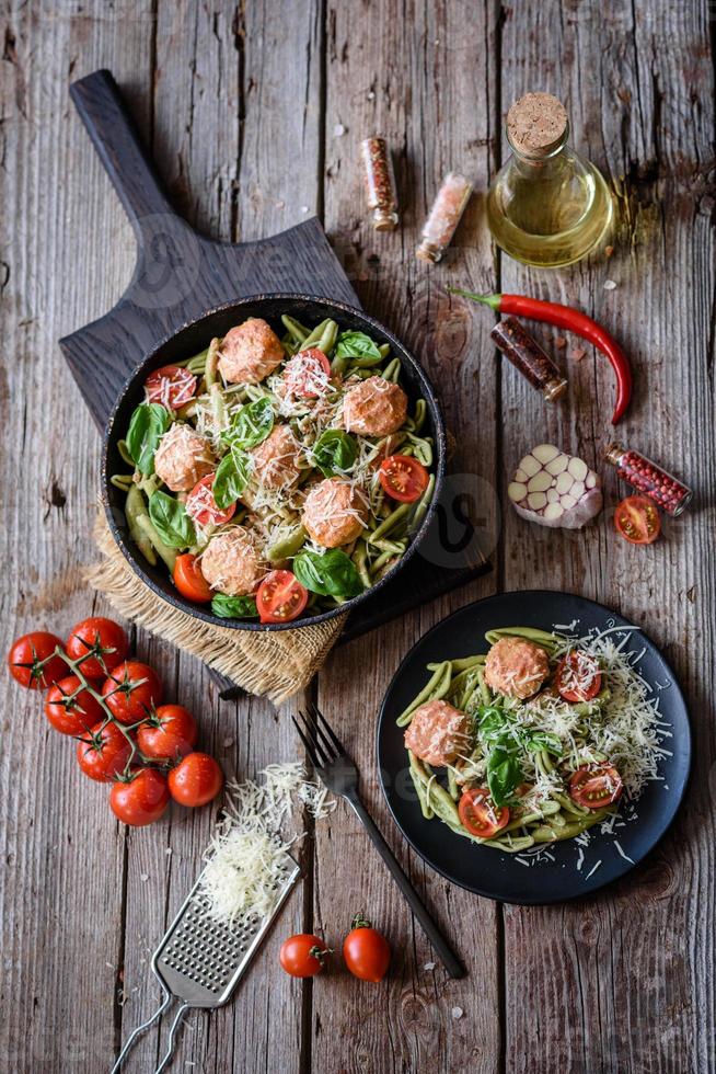 utsökt färsk pasta med köttbullar, sås, körsbärstomater och basilika foto