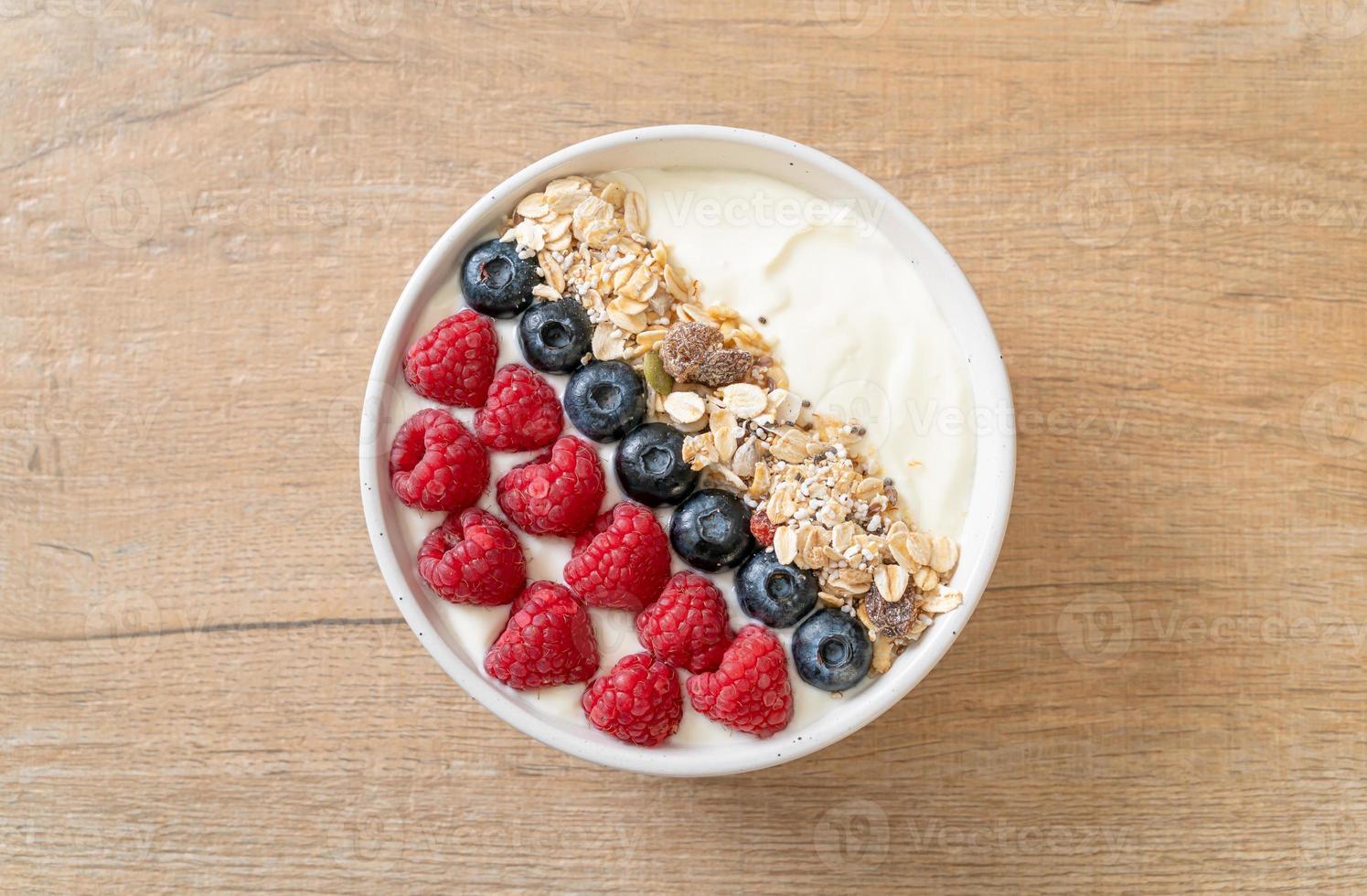 hemlagad yoghurtskål med hallon, blåbär och granola - hälsosam matstil foto