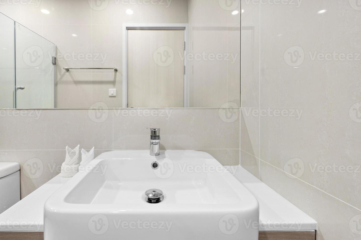 närbild litet handfat och spegel i litet badrum foto