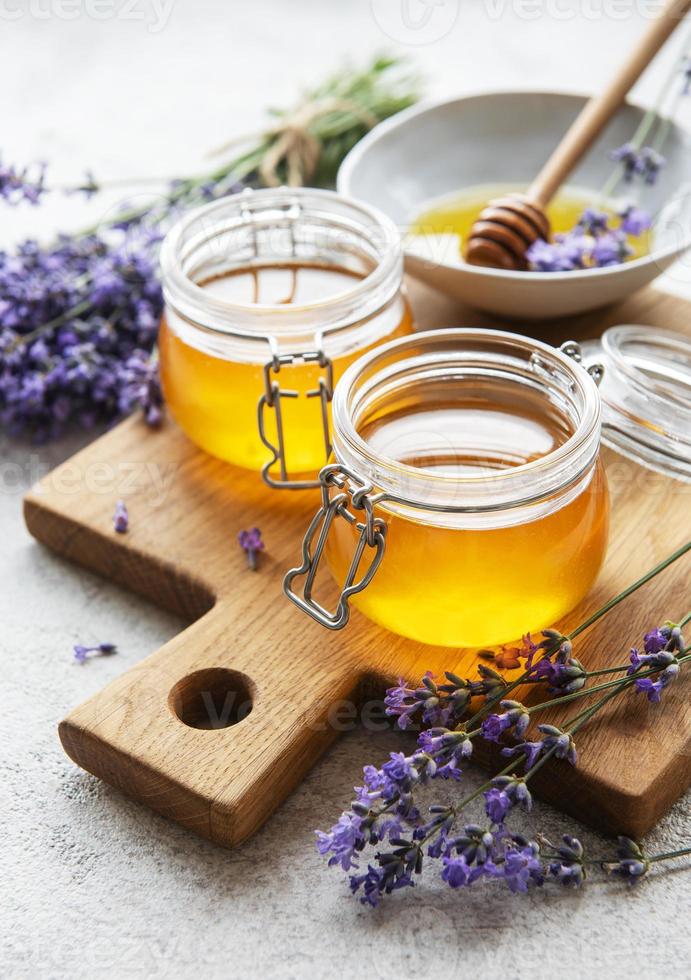 burkar med honung och färska lavendelblommor foto