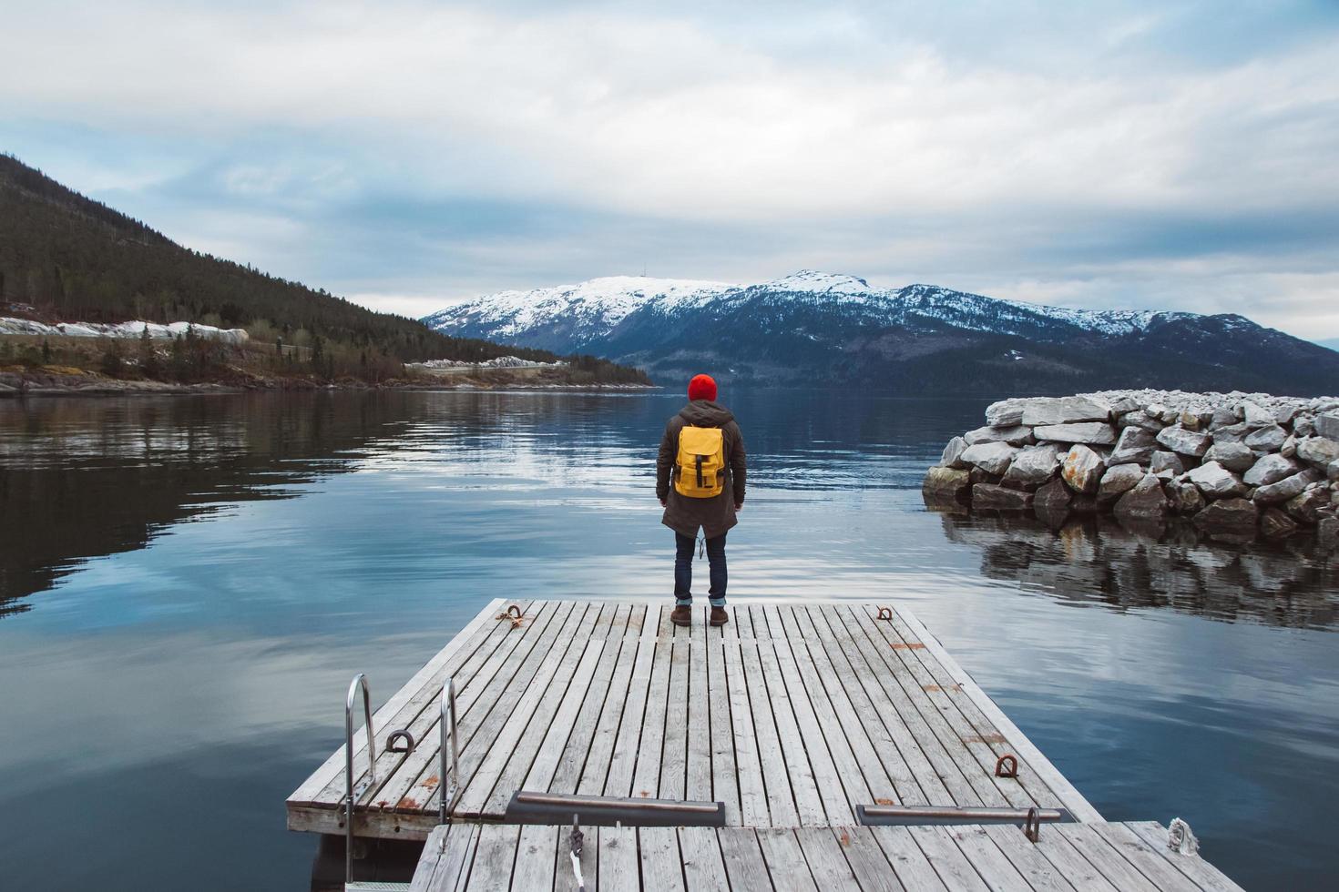 resenär man står på träbrygga på bakgrunden av berget foto