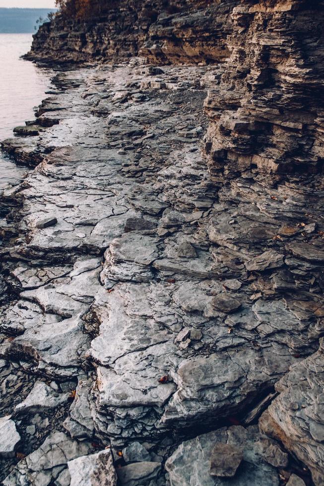 textur av en stenig strand nära vattnet. stenhög bakgrund foto