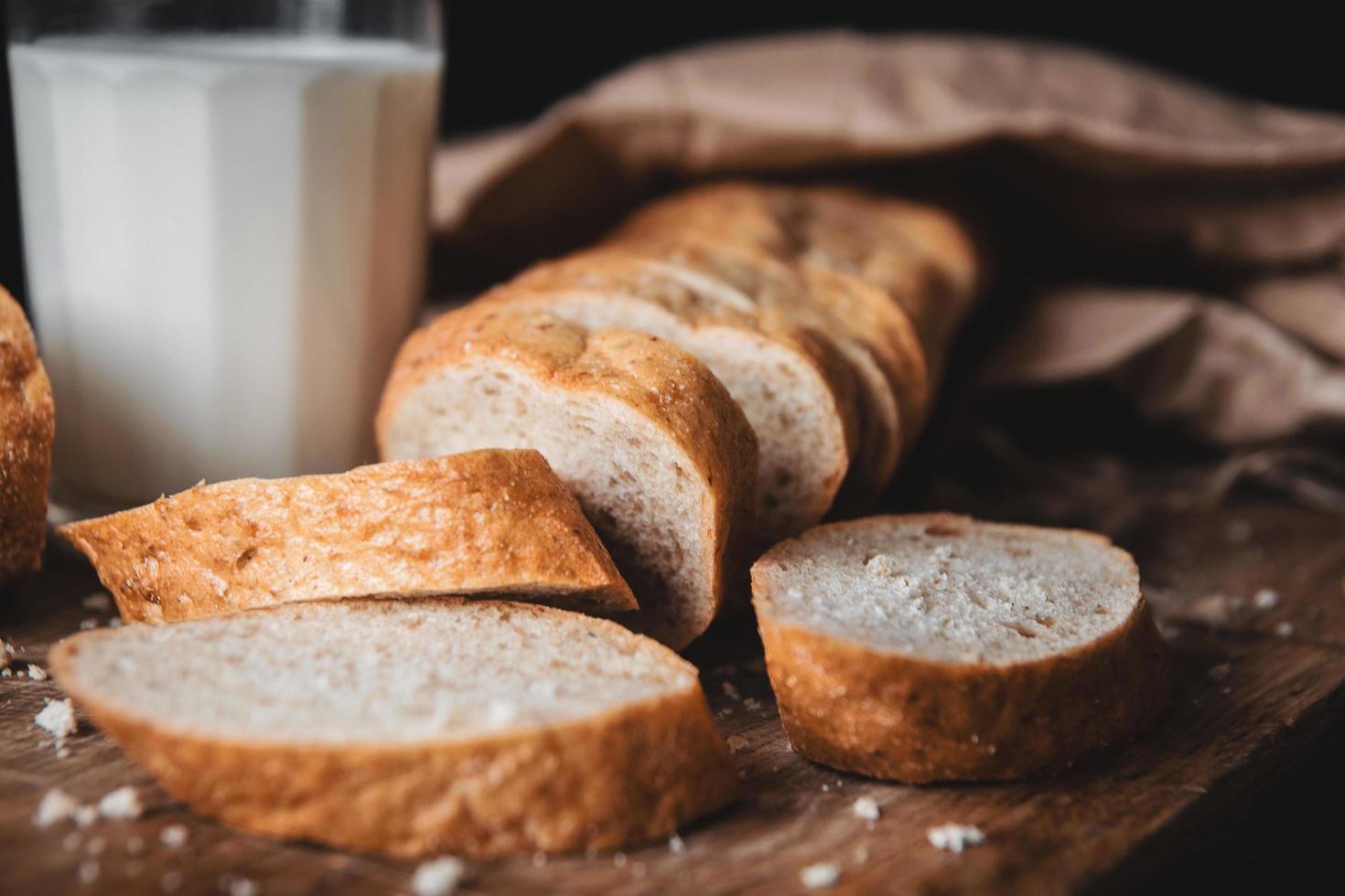 bröd på en träbräda och ett glas färsk mjölk foto