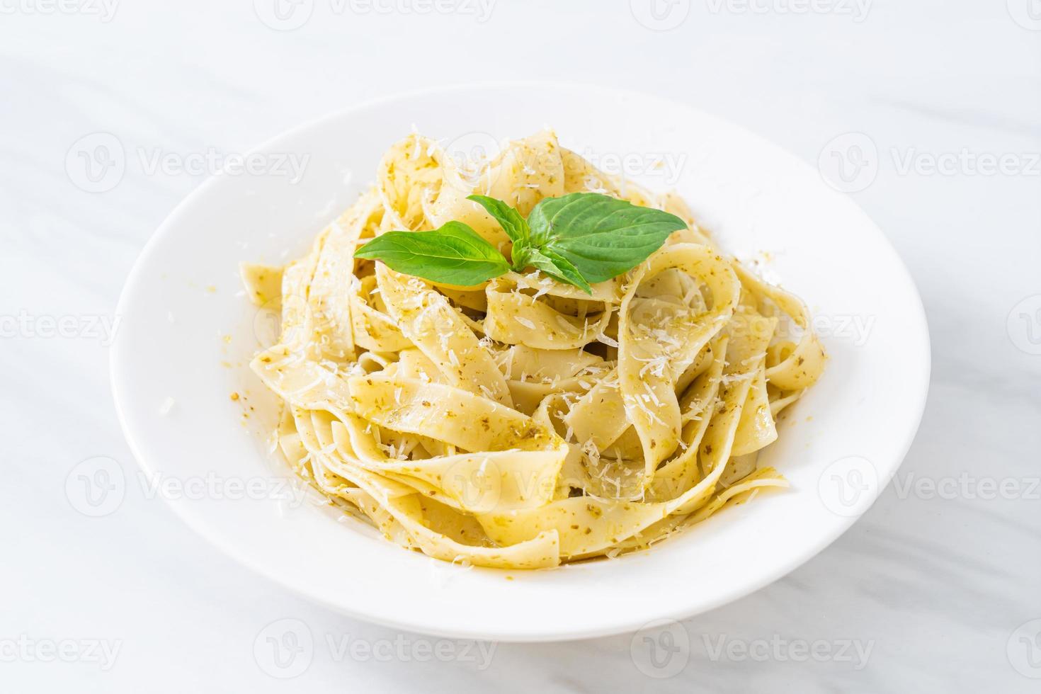 pesto fettuccine pasta med parmesanost på toppen - italiensk matstil foto