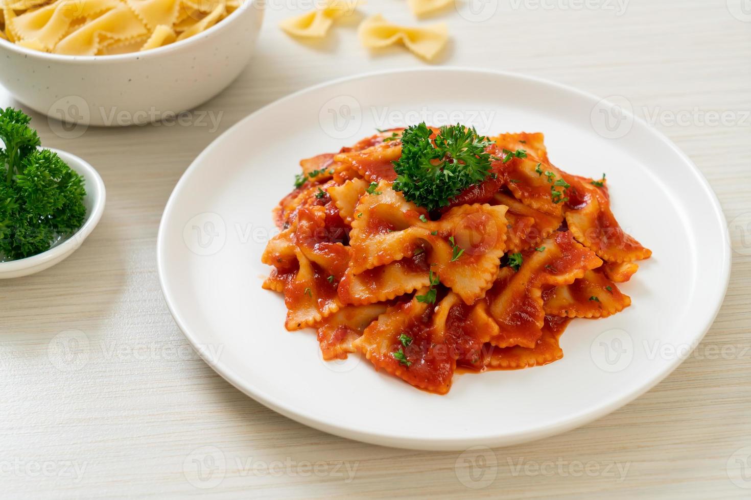 farfalle pasta i tomatsås med persilja - italiensk matstil foto