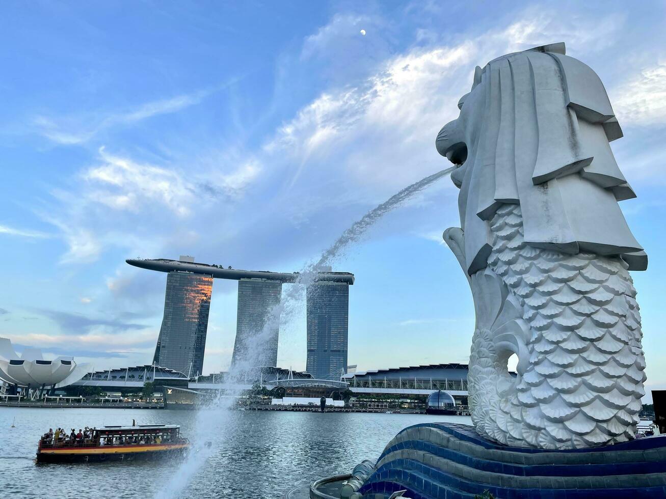 singapore augusti 27 2023 merlion staty fontän i merlion parkera och marina bukt sand singapore stad horisont på solnedgång himmel kväll. foto